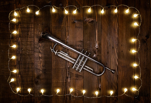 trumpet on wooden background with light bulbs