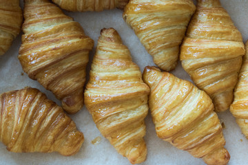 fresh croissants in cardboard box from top view.