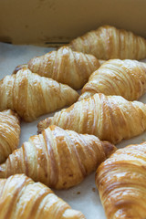 fresh croissants in cardboard box from top view.