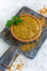 Bowl with grain mustard and yellow mustard seeds.