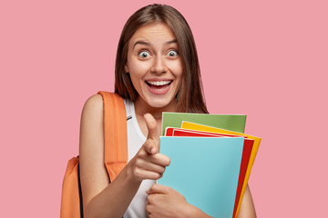 I choose you to help! Happy young Caucasian girl with pleasant appearance indicates directly at...