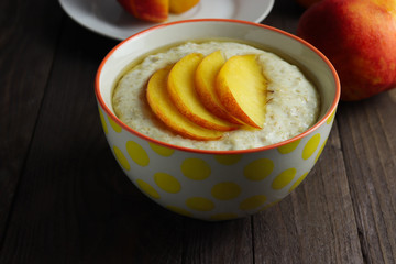 Oat porridge with sliced of nectarine and honey