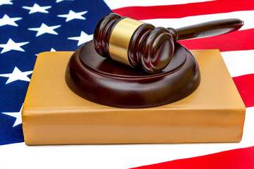 Judge's gavel with law book on american flag.