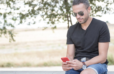 Attractive man, looking at his smartphone
