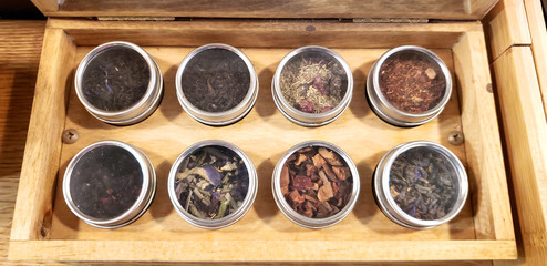 wooden tray with herbs and spices samples from a tilted angle view