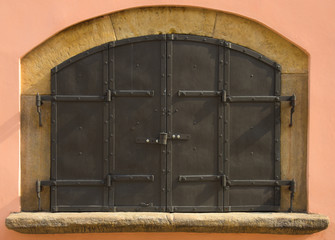 Old vintage window in Prague street with iron shutters