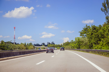 Fototapeta premium Verkehr auf Autobahn, Asphalt, Autos und blauer Himmel
