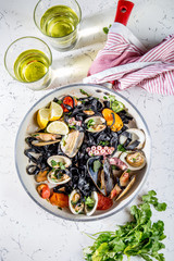 Homemade seafood Black pasta spaghetti with clams mussels octopus vongole in pan with white wine on marbled background