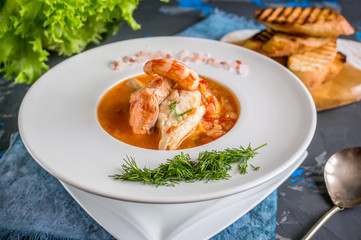 French fish soup Bouillabaisse with seafood, salmon fillet, shrimp, rich flavor, delicious dinner...