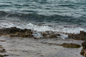 Small ocean sea waves on stone beach. Background picture with roaring waves.