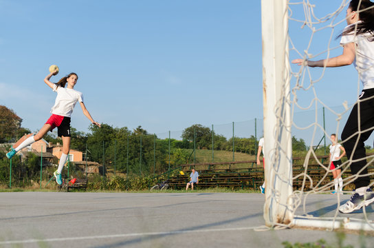 Young female handball player trowing a ball