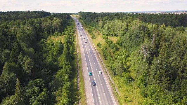 Aerial view of car driving through the forest on country road. Cip. Cars Driving Through Forest Road Drone Travel Countryside Adventure. Aerial view flying over old patched two lane forest road with
