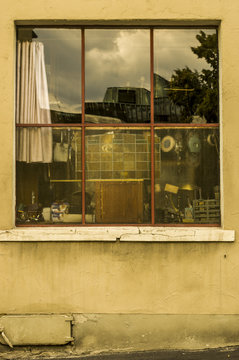 Fenster eines Tr&ouml;delladens mit Spiegelung in einer maroden Fassade, Window of a junk shop with reflection in a dilapidated facade