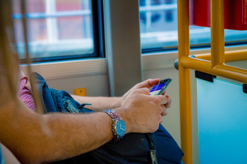 Close up on a man using a smartphone while he is traveling by bus in Warsaw Poland