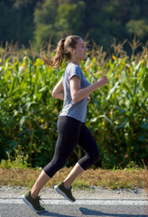 woman jogging along a country road