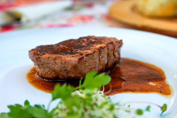 Grilled steak beef with sauce served on a white plate