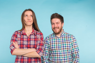 Fototapeta premium Funny young couple laughing and fooling around together on blue background.