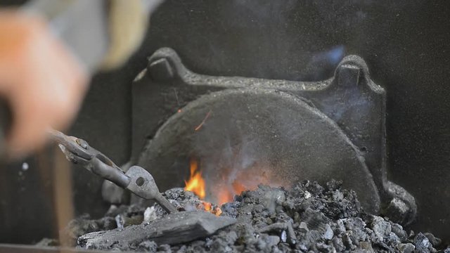 Blacksmith stoking the coals