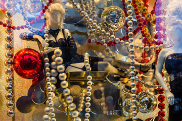 Female mannequin dressed in black lingerie and different christmas decorations in a showcase