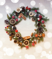 Christmas and  New Year background / a christmas wreath from spruce twigs,pine cones,cinnamon sticks,dry lemon,berries,balls and candies