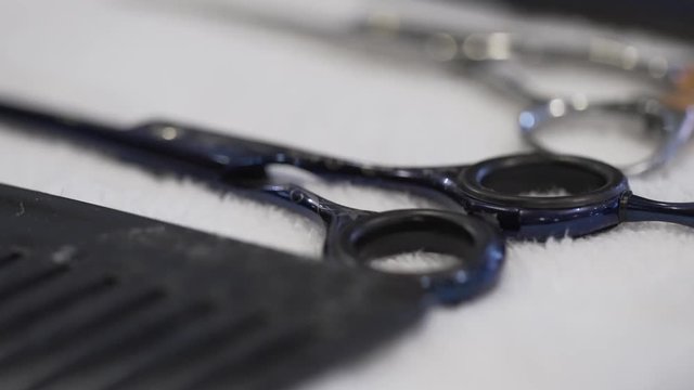 Black scissors and comb on the table macko slider