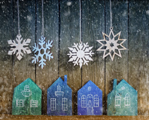 a New year and Christmas background / a miniature wooden toy houses,a lantern and a snowflakes over...