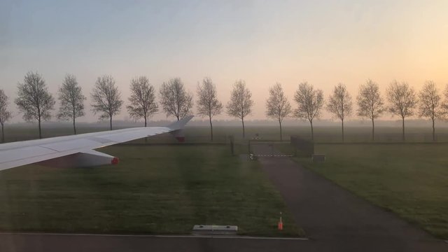Airplane landing at the Schiphol airport around sunset time
