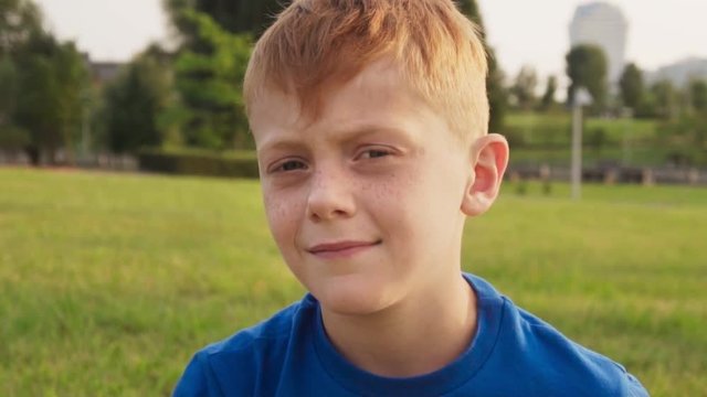 Sad little boy with stern gaze looking at camera