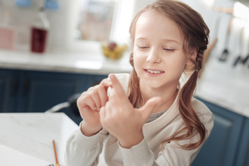 Fototapeta premium Lets count. Amazing blonde kid keeping smile on face while counting her fingers