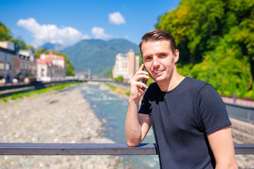 Fototapeta premium Man on the embankment of a mountain river in a European city.