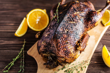 Homemade baked duck with oranges on a wooden background