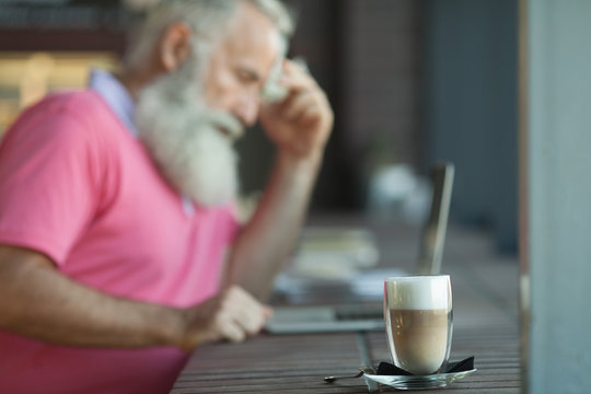 Coffee cup on the table in coffee shop as blur senior man background