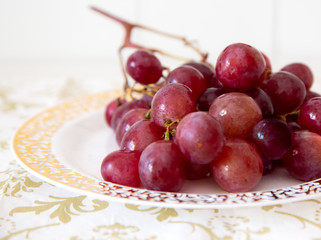 red grapes on a golden and white plate detail