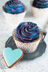 Cupcakes with galaxy dark whipped cream with heart cookie
