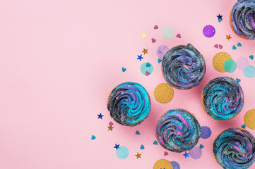 Cupcakes with galaxy dark whipped cream on pink party background