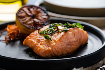 Salmon Sole Meuniere with lemon. Fillet of red fish. Steak trout fried with butter, lemon and parsley sauce