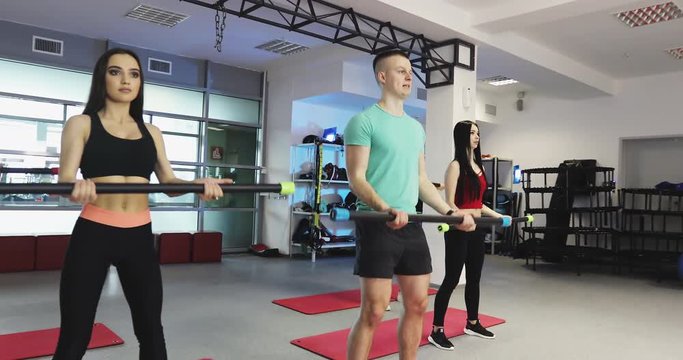 Fitness women is training with body bar at gym.