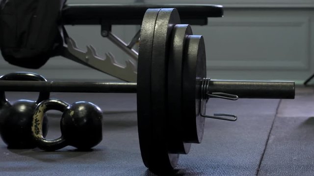 Moody darker 4k footage of free weights and metal plates in home garage gym