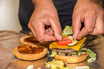 Hamburger Buns, Salat und Fleisch werden belegt