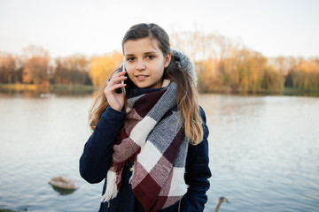 Dziewczyna rozmawia przez telefon w parku. Jesień.