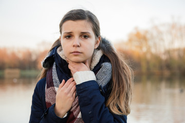 Chora dziewczyna siedzi w parku. Jesień.