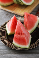 Cut pieces of ripe watermelon in a plate on a wooden table