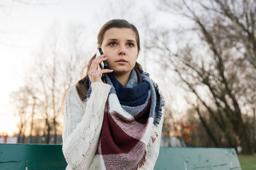 Dziewczyna rozmawia przez telefon w parku. Jesień.