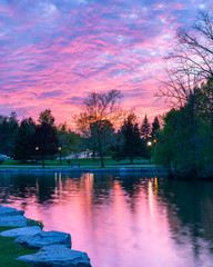 Sunset At A Park Near A River With Trees In The Background And A Sky That Looks Like Cotton Candy