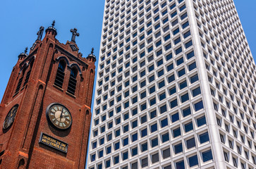 Old Brick Church With A Clock On It Next To A Modern White Skyscraper
