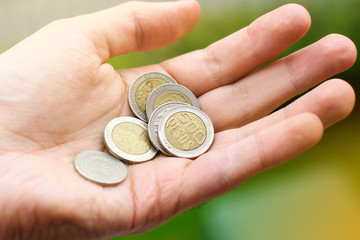 Fototapeta premium Colombian peso coins in man's hand