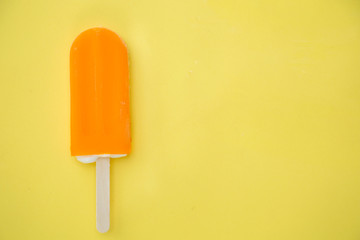 Popsicle with fresh orange on a table