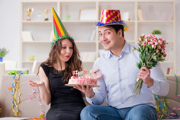 Young couple celebrating birthday with cake