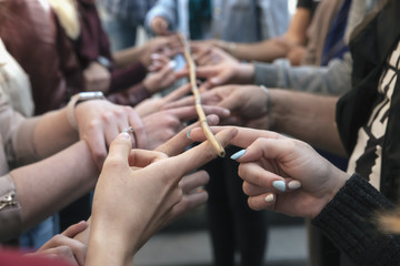 Obraz na płótnie Canvas conceptual image of teamwork, a group of people holding sticks holding a bamboo branch.