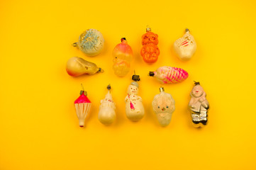 Fototapeta na wymiar Old fur-tree toys on a yellow background